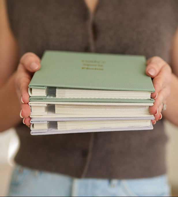 Travel Photo Albums stacked, showing linen covers and self-adhesive pages