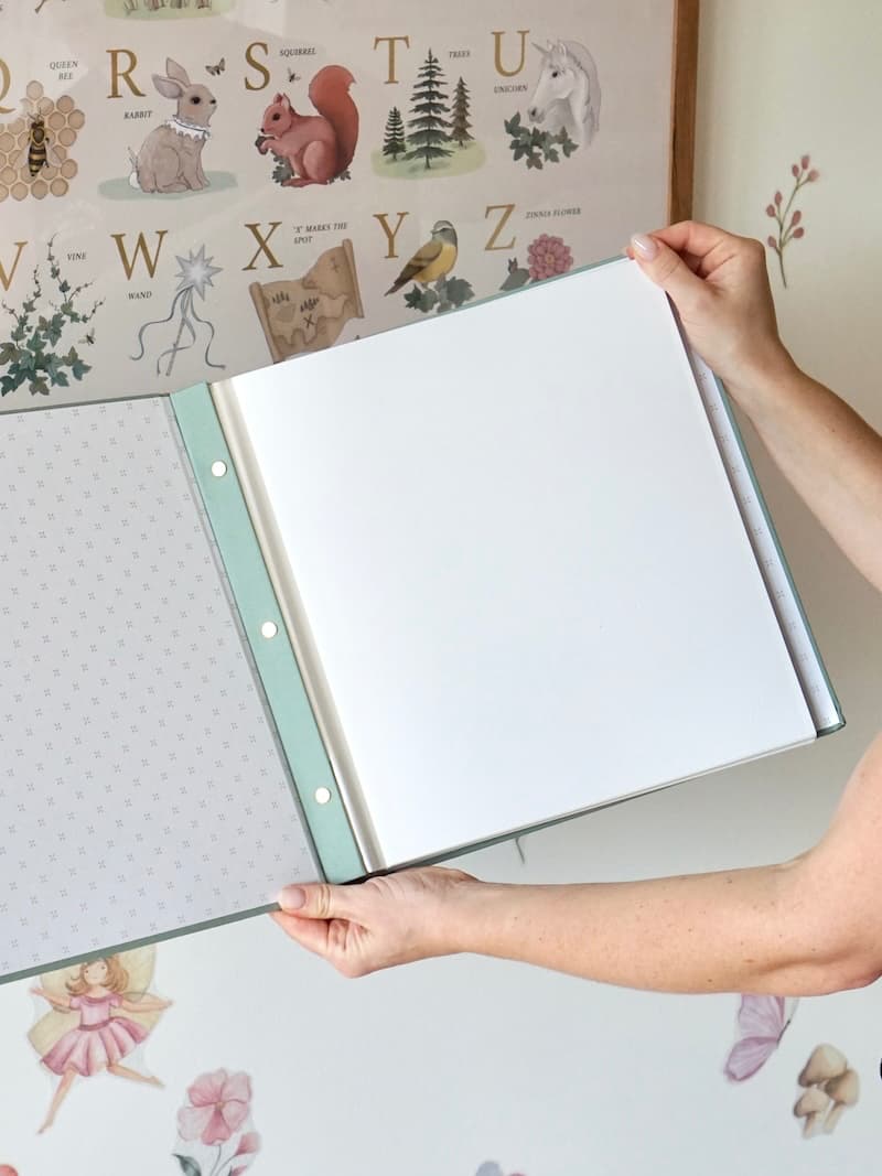 Sage green baby photo album open to self-adhesive pages